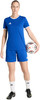 Eine Frau im blauen Fußballtrikot und Shorts hält einen Ball.
