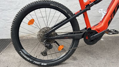 Ein rotes E-Bike mit schwarzen Rädern und Rahmendetails. Ein rotes E-Bike mit schwarzen Rädern und Rahmendetails.