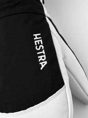 Detail eines Hestra-Handschuhs mit weißer Schrift auf schwarzem Hintergrund. Detail eines Hestra-Handschuhs mit weißer Schrift auf schwarzem Hintergrund.