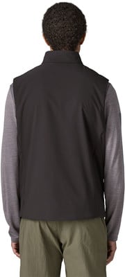 Rückansicht eines Mannes in einer schwarzen Weste und einem grauen Langarmshirt. Rückansicht eines Mannes in einer schwarzen Weste und einem grauen Langarmshirt.