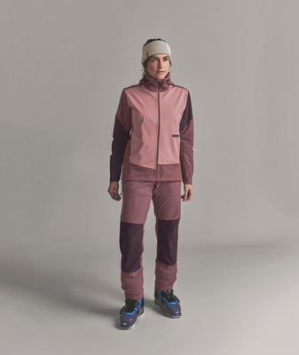 Frau in rosa Skijacke und Hose mit Mütze auf dem Kopf. Frau in rosa Skijacke und Hose mit Mütze auf dem Kopf.