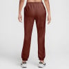 Damen-Jogginghose von Nike in Dunkelbraun mit weißen Sneakern.
