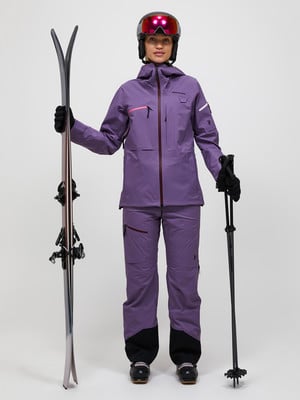 Eine Frau in Skikleidung mit Skiern und Stöcken auf weißem Hintergrund. Eine Frau in Skikleidung mit Skiern und Stöcken auf weißem Hintergrund.