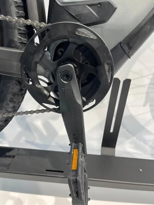 Detailaufnahme der Kurbel und Kette eines E-Bikes mit einem Kunststoffpedal. Detailaufnahme der Kurbel und Kette eines E-Bikes mit einem Kunststoffpedal.