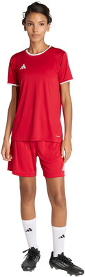 Eine Frau in einem roten Fußballtrikot mit weißem Besatz und Shorts. Eine Frau in einem roten Fußballtrikot mit weißem Besatz und Shorts.