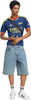 Ein junger Mann in einem Arsenal-Trikot und Jeans-Shorts mit Umhängetasche.