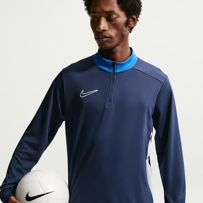 Ein Mann hält einen Fußball und trägt ein dunkelblaues Nike-Oberteil. Ein Mann hält einen Fußball und trägt ein dunkelblaues Nike-Oberteil.