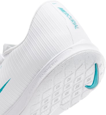 Bílý fotbalový trenér s tyrkysovým logem Nike a nápisem Mercurial. Bílý fotbalový trenér s tyrkysovým logem Nike a nápisem Mercurial.