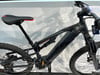 Schwarzes Mountainbike-E-Bike mit Federung und roten Details.