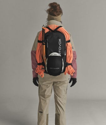 Rückansicht eines Bergsteigers mit Rucksack, Helm und Seil auf dem Rücken. Rückansicht eines Bergsteigers mit Rucksack, Helm und Seil auf dem Rücken.
