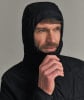 Ein Mann in schwarzer Kapuzenjacke richtet den Kragen mit der Hand.