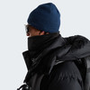 Mann in blauer Mütze und schwarzer Kapuzenjacke mit Schal.