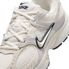 Részletes felvétel egy fehér Nike futóicipőről, szürke és bézs elemekkel.