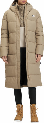 Damen-Steppmantel in Beige mit Kapuze, schwarzer Leggings und braunen Stiefeln. Damen-Steppmantel in Beige mit Kapuze, schwarzer Leggings und braunen Stiefeln.