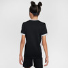 Rückansicht eines Mädchens in einem schwarzen T-Shirt mit weißen Streifen und schwarzen Shorts.
