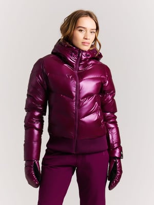 Junge Frau in glänzender lila Daunenjacke und Handschuhen. Junge Frau in glänzender lila Daunenjacke und Handschuhen.