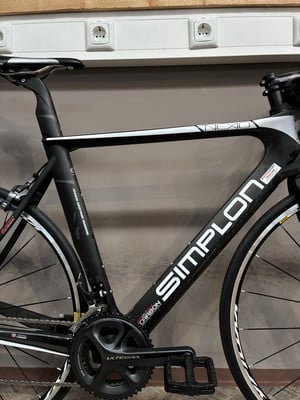 Schwarzes Simplon Rennrad mit weißem Schriftzug und Carbonrahmen. Schwarzes Simplon Rennrad mit weißem Schriftzug und Carbonrahmen.