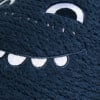 Detail einer blauen Strickoberfläche mit einem weißen gestickten Lächeln und Auge.