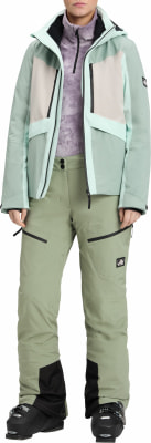 Damen-Skijacke und -hose in Pastellfarben mit Skischuhen. Damen-Skijacke und -hose in Pastellfarben mit Skischuhen.