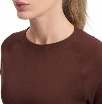 Detail von Hals und Schultern einer Frau in braunem Shirt.