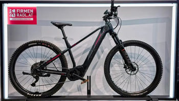 Schwarzes E-Mountainbike mit roten Details auf dem Display.