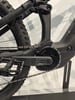 Detail der Rückseite eines schwarzen E-Bikes mit Kette und Pedal.
