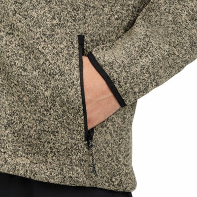 Hand in der Tasche, Detail eines Pullovers mit schwarzer Paspel und Reißverschluss. Hand in der Tasche, Detail eines Pullovers mit schwarzer Paspel und Reißverschluss.