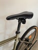Detail von Fahrradsattel und Sattelstütze mit rotem Rücklicht.