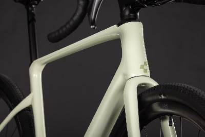 Detail eines hellgrünen Gravelbike-Rahmens mit Logo. Detail eines hellgrünen Gravelbike-Rahmens mit Logo.