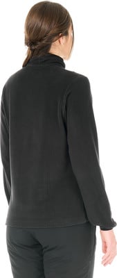Eine Frau in einem dunklen Rollkragenpullover und Hose, von hinten gesehen.