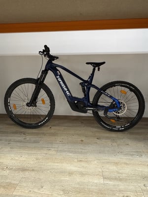 Dunkelblaues Haibike E-Bike mit Federung auf Holzboden. Dunkelblaues Haibike E-Bike mit Federung auf Holzboden.