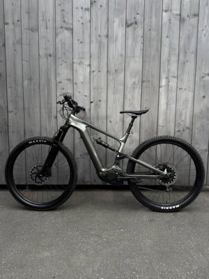 Ein E-Mountainbike steht vor einer Holzwand. Ein E-Mountainbike steht vor einer Holzwand.