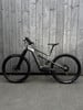 Ein E-Mountainbike steht vor einer Holzwand.