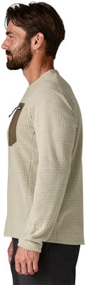 Mann in einem beigefarbenen Pullover mit brauner Brusttasche. Mann in einem beigefarbenen Pullover mit brauner Brusttasche.