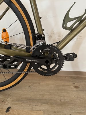 Detailaufnahme von Kurbel und Schaltwerk an einem grünen Fahrrad mit beigen Reifen. Detailaufnahme von Kurbel und Schaltwerk an einem grünen Fahrrad mit beigen Reifen.