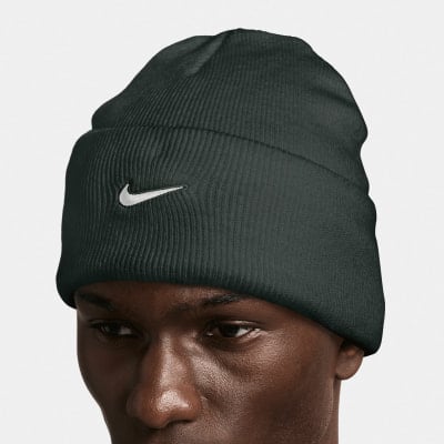 Ein Mann mit einer dunkelgrünen Nike-Mütze mit weißem Logo auf weißem Hintergrund. Ein Mann mit einer dunkelgrünen Nike-Mütze mit weißem Logo auf weißem Hintergrund.