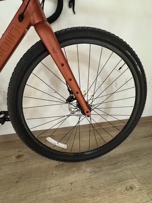 Vorderrad eines orangefarbenen Fahrrads mit Scheibenbremse und schwarzem Reifen. Vorderrad eines orangefarbenen Fahrrads mit Scheibenbremse und schwarzem Reifen.