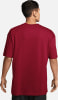 Ein Mann in einem dunkelroten Kurzarmshirt, Rücken zur Kamera gedreht.