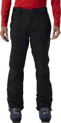 Ein Mann in schwarzer Skihose und rotem Oberteil, trägt Skischuhe. Ein Mann in schwarzer Skihose und rotem Oberteil, trägt Skischuhe.