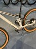 Ein weißes Mountainbike mit orangefarbenen Reifen und Cube-Logo am Rahmen.