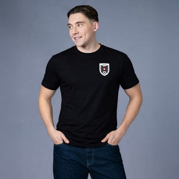 Ein Mann in einem schwarzen T-Shirt mit dem Logo des österreichischen Fußballverbands.