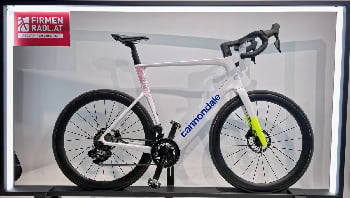 Modernes weißes Rennrad von Cannondale mit rosa und gelben Details.