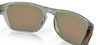 Transparente Brille mit verspiegelten Gläsern und orangefarbenem Oakley-Logo.