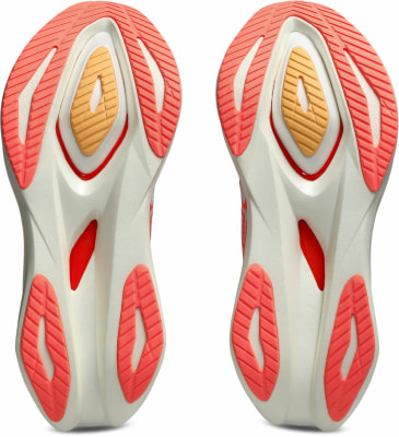 Nahaufnahme der Sohlen zweier Laufschuhe mit orangefarbenen und gelben Details. Nahaufnahme der Sohlen zweier Laufschuhe mit orangefarbenen und gelben Details.