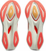 Nahaufnahme der Sohlen zweier Laufschuhe mit orangefarbenen und gelben Details.