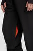 Detail einer schwarzen Hose mit oranger Tascheninnenfutter.