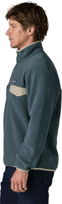 Mann in blaugrünem Fleece-Pullover mit beiger Tasche und Logo. Mann in blaugrünem Fleece-Pullover mit beiger Tasche und Logo.