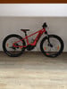 Ein rotes KTM E-Mountainbike mit dicken Reifen auf Holzboden.