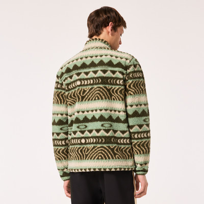 Rückansicht eines Mannes in einer grünen Fleecejacke mit geometrischem Muster.