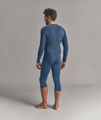 Ein Mann in einem dunkelblauen Langarmshirt und Dreiviertel-Leggings, von hinten gesehen. Ein Mann in einem dunkelblauen Langarmshirt und Dreiviertel-Leggings, von hinten gesehen.